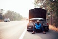 Serious african man holding his head by hands standing near his old broken car  with raised hood on the highway road Royalty Free Stock Photo