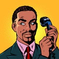 Serious african man talking on a retro phone Royalty Free Stock Photo