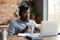 Serious Afro American student guy in headphones watching learning webinar Royalty Free Stock Photo