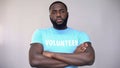 Serious Afro-American volunteer standing with hands crossed, altruistic activity