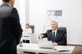 Serious aged employer having conversation in the office