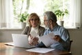 Serious aged family couple review financial documents at home office Royalty Free Stock Photo