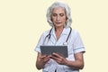 Serious aged female doctor using tablet pc. Royalty Free Stock Photo