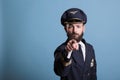 Serious airplane aviator pointing at camera with finger