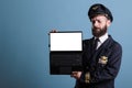 Serious airplane pilot showing laptop with empty white screen