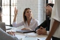 Serious ambitious businesswoman raise hand ask question to diverse presenter.