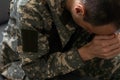Serious anxious and nervous military man suffers from depression while sitting alone at home. Pensive man in military