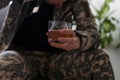 Serious anxious and nervous military man suffers from depression while sitting alone at home. Pensive man in military