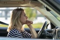 Serious anxious woman driving car. Female driver of middle age pensive sad waiting in traffic jam