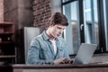 Serious appealing man working on laptop