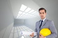 Serious architect holding plans and hard hat Royalty Free Stock Photo
