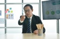 Serious Asian business man boss sitting  and pointing for command at desk in office meeting room Royalty Free Stock Photo