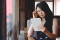 Serious Asian businesswoman is reading and having a headache with online news on tablet at modern office. Healthy and technology Royalty Free Stock Photo