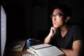 Serious asian man studying with books and computer