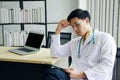 Serious Asian Psychiatrist MD man is researching with laptop for mental health problems in clinical depression people life.