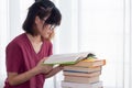 Serious Asian teen girl with eyeglasses pay attention reading book for examination or competition, university student read book at Royalty Free Stock Photo