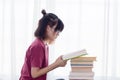 Serious Asian teen girl with eyeglasses pay attention reading book for examination or competition, university student read book at Royalty Free Stock Photo