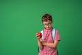 Serious, attentive boy with glasses holds books and an Apple in his hands