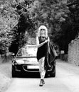 Woman walking with sports car B&W