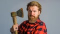 Serious bearded man with axe. Man in checkered shirt with old ax. Canadian lumberjack with with hatchet. Closeup Royalty Free Stock Photo