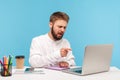 Serious bearded man boss scolding his employees pointing finger at laptop display, conducting online video conference sitting in Royalty Free Stock Photo