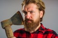 Serious bearded man with hatchet. Canadian lumberjack with old axe. Cutting wood. Logger tools. Royalty Free Stock Photo