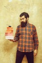 Serious bearded man holding colorful gift boxes stacked in hands Royalty Free Stock Photo