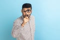 Man holding magnifying glass and looking at camera with big zoom eye, having strict bossy expression Royalty Free Stock Photo