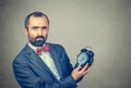 Serious bearded man holding showing alarm clock in his hand Royalty Free Stock Photo
