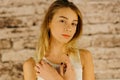 The serious beautiful teenage girl with blond hair. The close-up portrait.