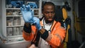 Serious Black African American Paramedic Puts on Blue Surgical Rubber Gloves in an Ambulance Vehic