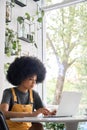 Serious black girl sitting in cafe with laptop typing learning online, working. Royalty Free Stock Photo