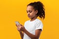 Serious black girl using mobile phone at studio Royalty Free Stock Photo