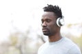 Serious black man listening to music wearing headphones Royalty Free Stock Photo