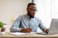 Serious Black Man Writing Business Report At Laptop In Office Royalty Free Stock Photo