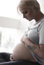 Severe pregnant woman hugging her tummy Royalty Free Stock Photo