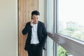 Serious boss asian businessman talking on the phone in a modern office center, makes a working call to colleagues Royalty Free Stock Photo