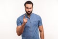 Serious bossy man with beard in blue shirt warning with finger, scolding, strictly looking at camera Royalty Free Stock Photo