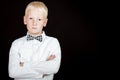 Serious boy with arms crossed wearing bow tie Royalty Free Stock Photo