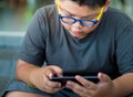 Asian boy have a serious face while playing game on smartphone Royalty Free Stock Photo