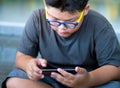 Asian boy have a serious face while playing game on smartphone Royalty Free Stock Photo