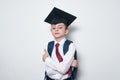 Serious boy in school uniform and graduate hat on white background. Junior High School education