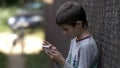 Serious boy is using the phone in the countryside Royalty Free Stock Photo