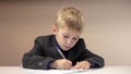 Serious boy writing on his notebook