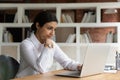 Serious brooding Indian businesswoman working on on-line project