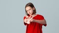 Serious brunette teen girl stretch out hand, showing stop sign with confident face expression, rejecting something, saying no, Royalty Free Stock Photo