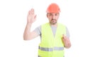 Serious builder rising his right hand and swearing false