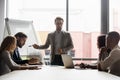 Serious business coach gives knowledge to diverse staff during seminar Royalty Free Stock Photo