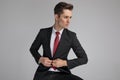 Serious business man buttoning his lounge jacket while looking away Royalty Free Stock Photo