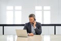 Serious business man in suit in office talk on phone. Office worker using phone, office call center. Man talk on phone